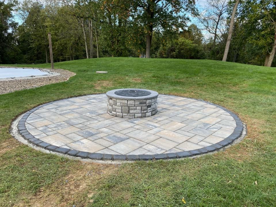 Circular patio and fire pit area by JM Outdoor Services