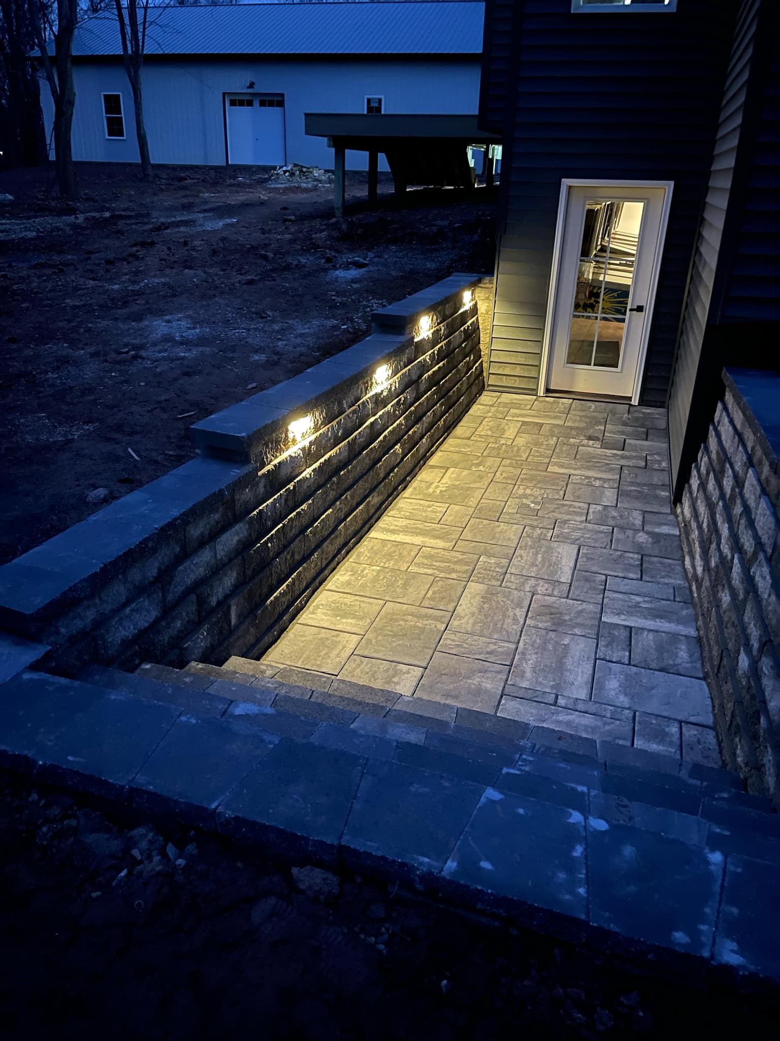 Paver landing with retaining walls and integrated lighting
