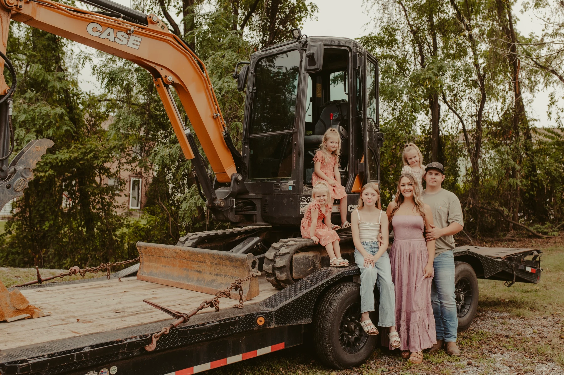 Jason Moore and family beside JM Outdoor Services equipment